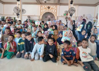 Siswa SD TQ Ibnu Katsir bersama para guru menyerahkan bantuan perlengkapan sekolah kepada anak-anak korban banjir di Gampong Menasah Raya, Kabupaten Pidie Jaya, Minggu (18/1/2026)
