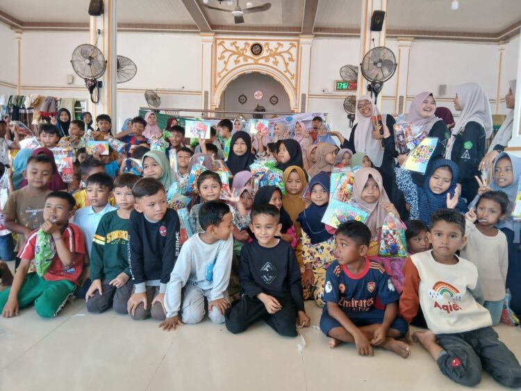 Siswa SD TQ Ibnu Katsir bersama para guru menyerahkan bantuan perlengkapan sekolah kepada anak-anak korban banjir di Gampong Menasah Raya, Kabupaten Pidie Jaya, Minggu (18/1/2026)