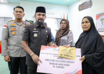 Bupati Aceh Timur Iskandar Usman Al-Farlaky menyerahkan santunan kematian dari Kemensos RI kepada 58 ahli waris korban banjir bandang-longsor di Aceh Timur. (Foto: Ist)