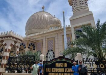 Pantulan cahaya lampu Masjid Haji Keuchik Leumik pada malam Ramadan yang menghadirkan suasana tenang dan sakral bagi para jamaah yang beribadah di tepian sungai Lamseupeung. (Foto: Dok. Infoaceh/Istimewa)