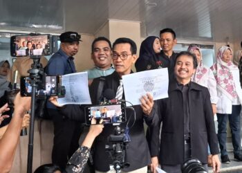Tersangka kasus dugaan pencemaran nama baik, Roy Suryo, menunjukkan dua lembar salinan ijazah terlegalisasi milik Presiden ke-7 RI Joko Widodo di Mapolda Metro Jaya, Jakarta, Kamis (12/2/2026).