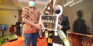 Asintel Kejati Aceh Mohamad Rohmadi SH MH menyerahkan hadiah kepada Aida Sasmitha, juara I Duta Pelajar Sadar Hukum Aceh 2021 di Hotel Grand Aceh Syariah Banda Aceh, Sabtu (27/11) malan