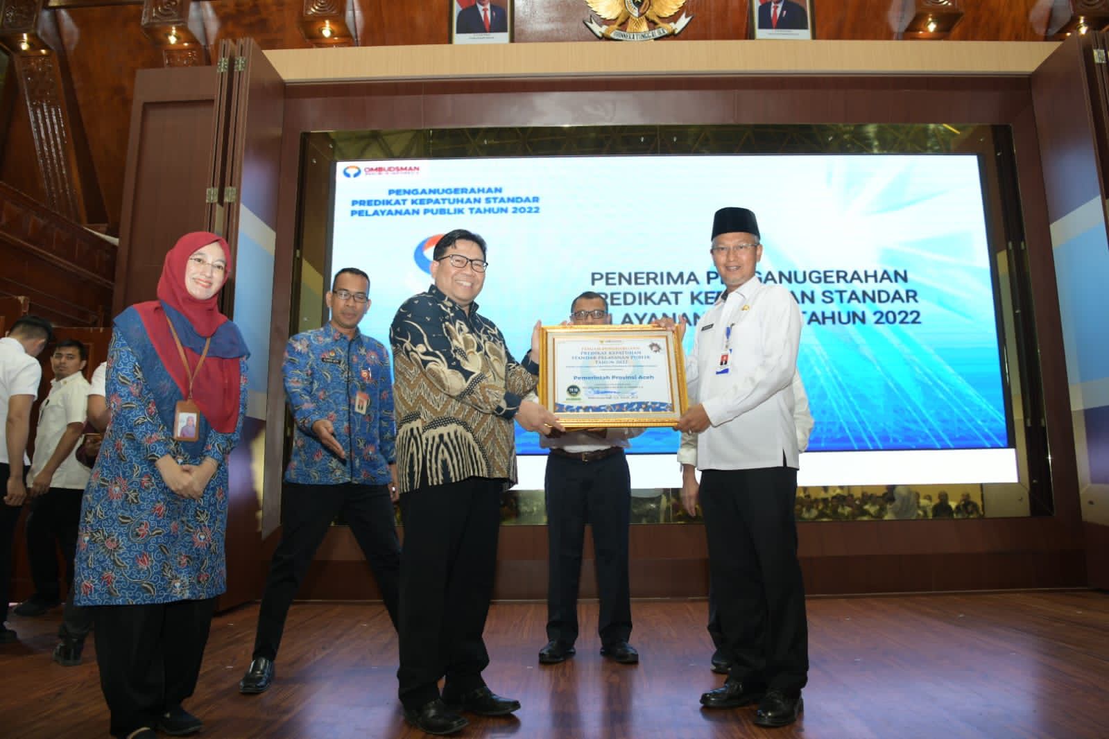 Asisten III Bidang Administrasi Umum Setda Aceh Dr Iskandar AP atas nama Pemerintah Aceh, menerima penghargaan pelayanan publik yang diserahkan oleh Anggota Ombudsman RI Dadan Suparjo Suharmawijaya, di Anjong Mon Mata Banda Aceh, Rabu (22/2)