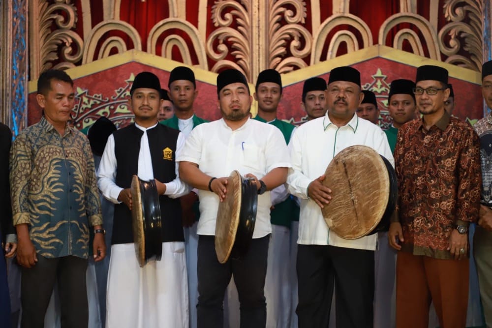 Pj Bupati Aceh Besar Muhammad Iswanto didampingi Anggota DPRK dan sejumlah pimpinan OPD Aceh Besar memukul rapa'i saat meresmikan Grup Hadrah Shalawat Baitul Qur'an Aceh Besar di Balai Baitul Quran Gampong Lamtimpeung Kecamatan Darussalam, Sabtu malam (4/3