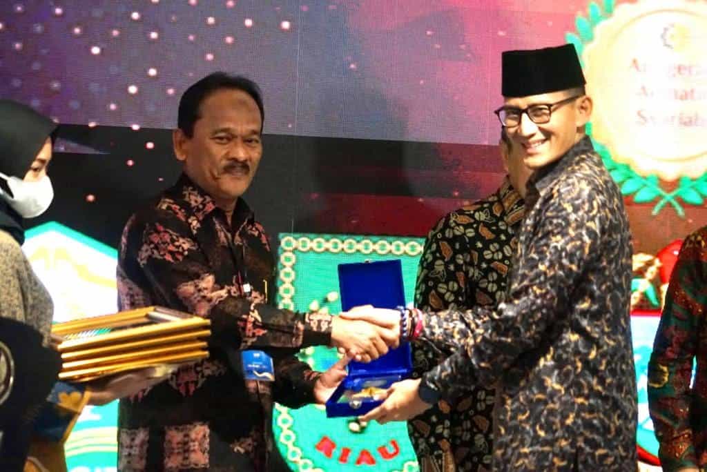 Menteri Pariwisata dan Ekonomi Kreatif Sandiaga Uno menyerahkan penghargaan kategori Keuangan Syariah kepada Plt Asisten II Bidang Perekonomian dan Pembangunan Setda Aceh Mawardi pada Anugerah Adinata Syariah 2023 di Tower BSI, Lantai 6, Jakarta Selatan, Jum'at (26/5)