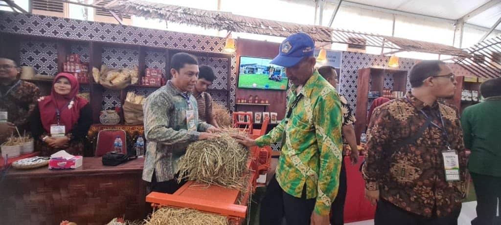 Nurwahidi, salah seorang inventor Mesin Press Jerami Portabel menjelaskan kegunaan dan sistem operasi mesin tersebut kepada pengunjung stand Aceh, di Penas-KTNA XVI, di Lanud Tabing, Padang, Sabtu (10/6)