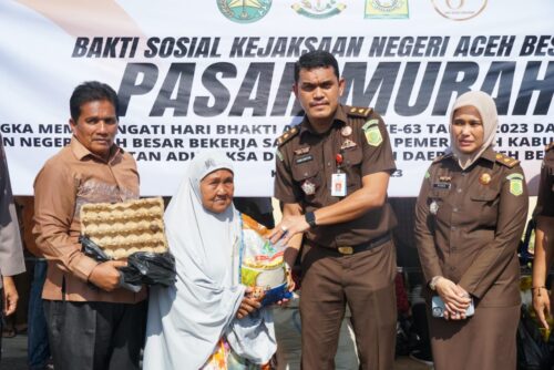 Kepala Dinas Pangan Fuadi Ahmad dan Plh Kajari Aceh Besar Yudi Saputra SH menyerahkan sembako murah secara simbolis kepada warga Kota Jantho, Kamis (23/6)