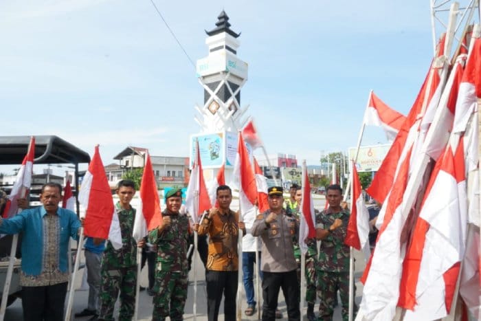 Camat Ingin Jaya Al Mubarak Akbar bersama Kapolsek Ipda Izazaya dan Danramil Kapten Arh Hamka Siregar saat memasang bendera Merah Putih di kawasan Bundaran Lambaro, Aceh Besar, Jum'at (4/8)