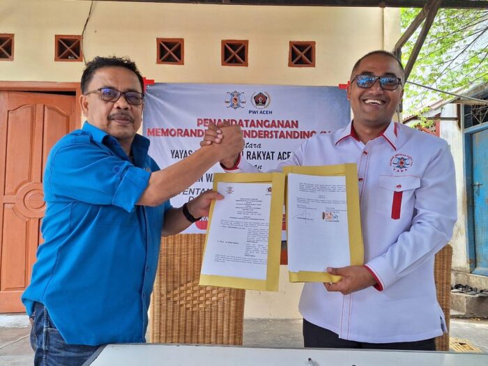Ketua PWI Aceh Nasir Nurdin dan Ketua YARA Safaruddin memperlihatkan dokumen MoU tentang pemberian bantuan dan pendidikan hukum setelah penandatanganan kesepahaman bersama di Warkop Sanusi, Banda Aceh, Rabu (20/9). (Foto: Dok. PWI Aceh)