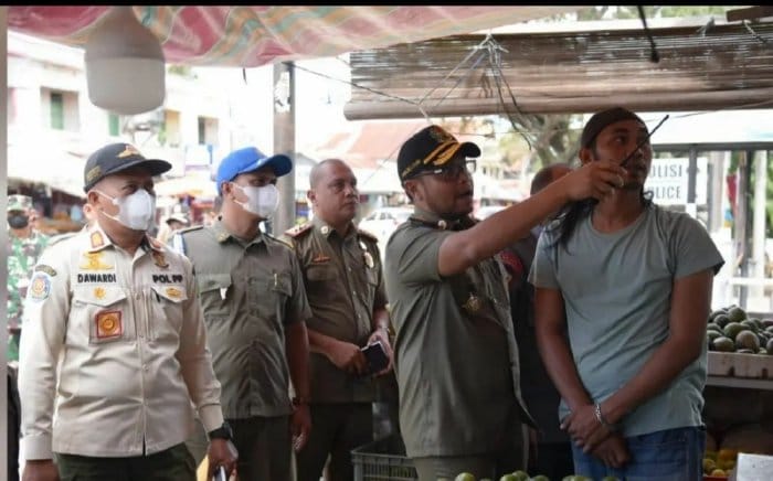 Kasat Pol PP-WH Aceh Besar Muhajir memberikan sosialisasi tentang identifikasi rokok ilegal kepada pedagang kios dan kedai kelontong yang berada di Lambaro, Kecamatan Ingin Jaya, Kamis (21/9)