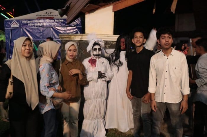 Para pengunjung ikut foto bersama pocong di pameran foto budaya dan wisata dan juga menampilkan pocong dan kuntilanak di teras samping Dekranasda Aceh Komplek Taman Sulthanah Safiatuddin, Banda Aceh, Sabtu malam (4/11/2023)