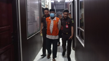 Tim penyidik Kejari Pidie Jaya menggiring mantan Direktur PDAM Tirta Krueng Meureudu ke mobil tahanan. (Foto: Dok. Kejari Pidie Jaya)