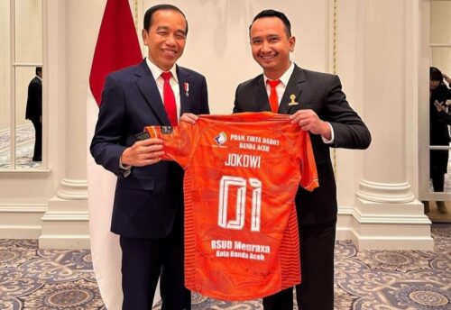 Presiden Joko Widodo bersama Manajer Persiraja, Ridha Mafdhul Gidong membentangkan jersey Persiraja di Washington DC, Amerika Serikat, Selasa (14/1) waktu setempat