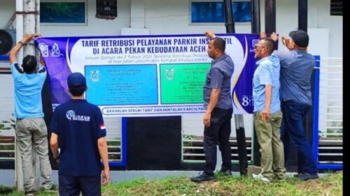 Petugas Dishub Kota Banda Aceh saat melakukan pemasangan spanduk tarif parkir insidentil selama PKA 8 di beberapa titik lokasi sekitar Taman Sulthanah Safiatuddin, Jum’at (3/11)