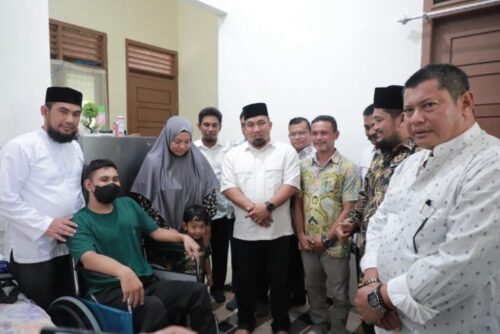 Pj Bupati Aceh Besar Muhammad Iswanto didampingi Kadisdikbud Aceh Besar Bahrul Jamil menyerahkan kursi roda kepada guru yang menderita sakit penyempitan saraf/lumpuh Syafrizal SPd, guru MAS Al Manar, Lampermai, Krueng Barona Jaya, Jum’at (24/11)