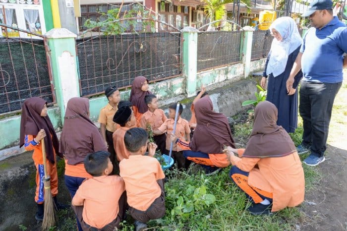 Sekda Aceh Besar Sulaimi bersama istri berdialog dengan murid sekolah dalam kegiatan aksi 1 jam memungut sampah di SDN Lamreung, Kreung Barona Jaya, Aceh Besar, Sabtu (25/11)