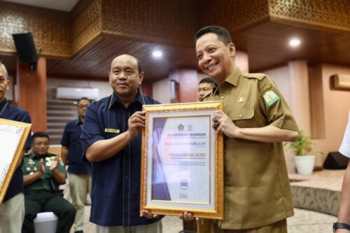 Pj Gubernur Aceh Achmad Marzuki menerima penghargaan atas capaian sebagai Instansi Pemerintah dengan Tingkat Kolaborasi Pelaksanaan APBN - APBD Tertinggi dari Kakanwil DJPb Aceh Izharul Haq di Kantor Gubernur Aceh, Selasa (5/12)