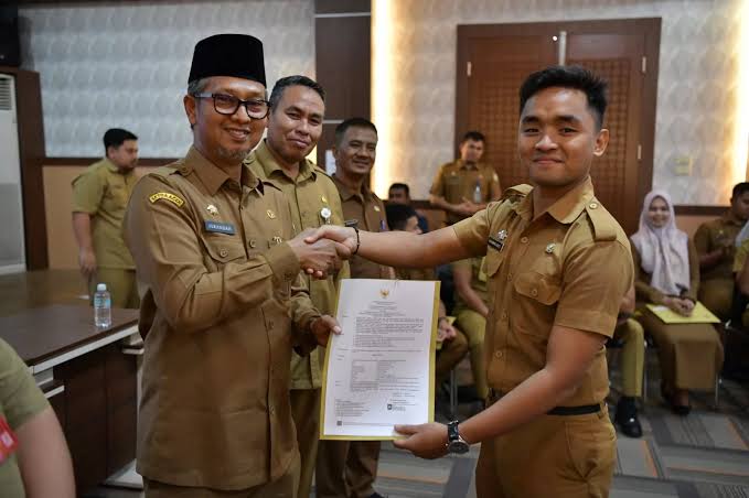 Asisten III Setda Aceh Dr Iskandar AP, menyerahkan dokumen kepegawaian dalam rangka penempatan tugas lulusan IPDN Aceh Angkatan XXIX, di aula Badan Kepegawaian Aceh (BKA), Selasa (19/12)