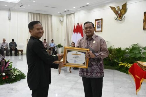 Ketua Komisi Informasi Pusat Doni Yusgiantoro menyerahkan penghargaan Anugerah Keterbukaan Informasi Publik kepada Kechik Kuta Barat, Sabang, Muhammad Hamim di Istana Wakil Presiden, Jakarta, Selasa (19/12)
