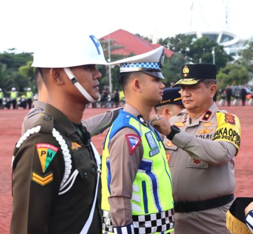Wakapolda Aceh Brigjen Pol Armia menyematkan pita kepada petugas TNI/Polri dan Dishub saat memimpin apel gelar pasukan Operasi Lilin Seulawah 2023 di halaman Mapolda Aceh, Kamis (21/12). (Foto: Dok. Humas Polda Aceh)