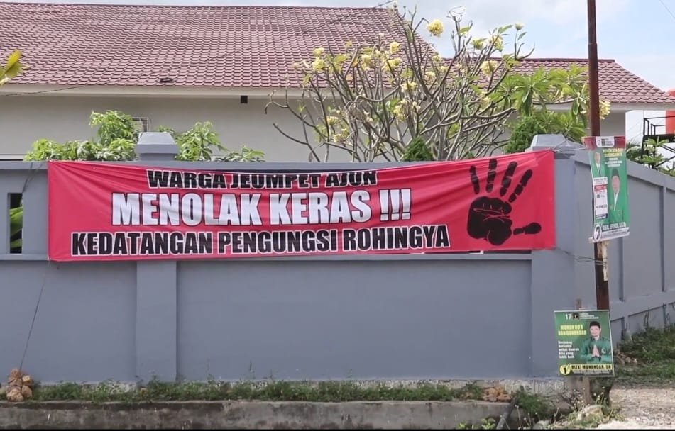 Spanduk dipasang warga yang menolak pengungsi Rohingya dipindahkan ke Markas PMI Aceh di Gampong Ajuen Jeumpet Kecamatan Darul Imarah Aceh Besar