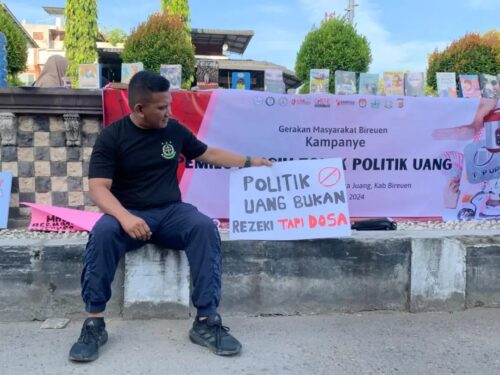 Kajari Bireuen Munawal Hadi SH MH memegang poster tolak politik uang pada aksi di Bireuen, Ahad (4/2)