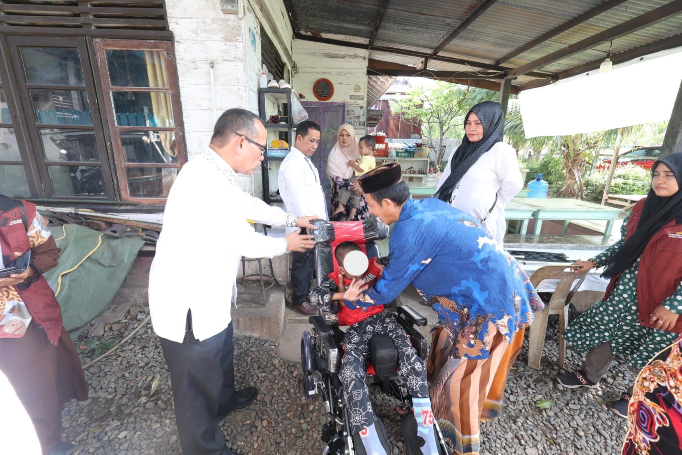 Kadis Sosial Aceh Muslem Yacob menyerahkan bantuan kursi roda adaptif kepada anak penderita cerebral palsy di Gampong Peuniti, Kecamatan Baiturrahman, Banda Aceh, Jum'at (23/2)