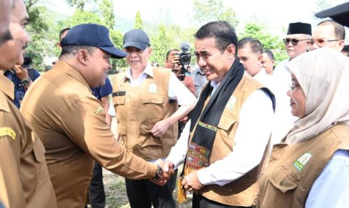 Sekda Aceh Besar Sulaimi menyambut Menteri Pertanian RI Andi Amran Sulaiman dengan mengalungkan sal saat tiba di Demplot Yonif 112/DJ di Gampong Deunong, Kecamatan Darul Imarah, Aceh Besar. (6/2/2024). (Foto: Dok. MC ACEH BESAR)