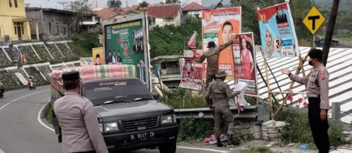 Petugas Satpol PP dibantu personel kepolisian mencopot dan menurunkan alat peraga kampanye pada tahapan masa minggu tenang pada Pemilu 2024, Ahad (11/2)