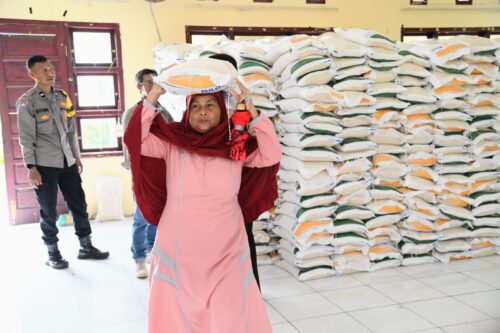 Masyarakat kurang mampu membawa bantuan Cadangan Beras Pemerintah (CPP) di aula Kantor Camat Krueng Barona Jaya, Aceh Besar, Kamis (29/2)