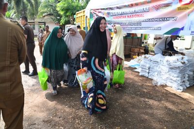 Nurlina saat membawa pulang paket pangan murah, di Mesjid Baitul Kiram, Peukan Biluy, Kecamatan Darul Kamal, Kabupaten Aceh Besar, Senin (1/4/2024). (FOTO/MC ACEH BESAR)
