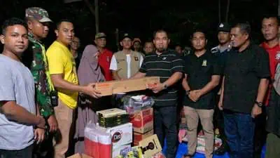 Pj Bupati Aceh Besar Muhammad Iswanto menyerahkan bantuan masa panik kepada korban kebakaran lima rumah di Meunasah Manyang, Krueng Barona Jaya, Aceh Besar, Sabtu malam (20/4/2024). (FOTO/MC ACEH BESAR)