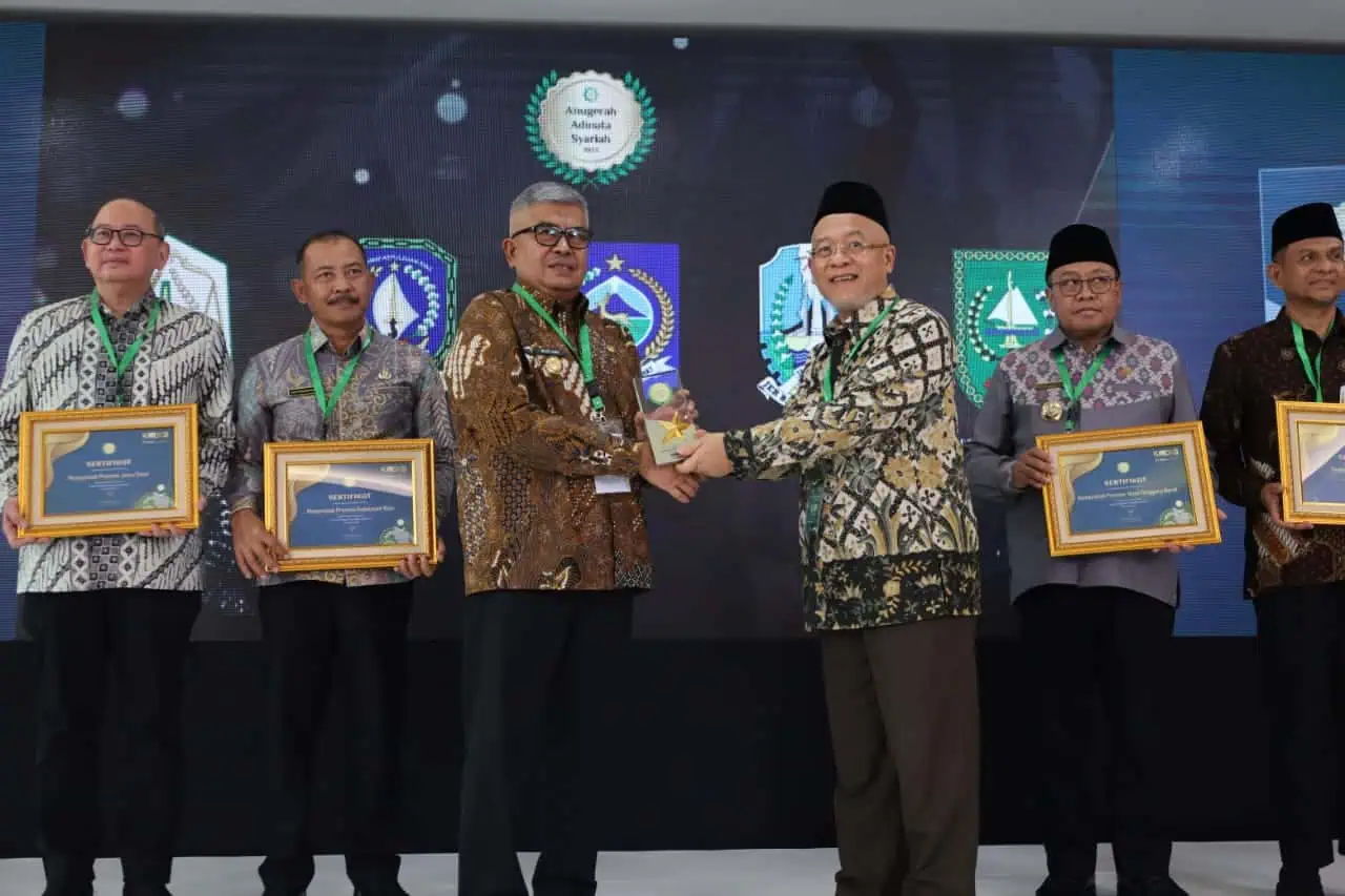 Plt Direktur Eksekutif KNEKS Taufik Hidayat menyerahkan penghargaan kepada Pj Gubernur Aceh Bustami Hamzah, di Menara Syariah, Pantai Indah Kapuk 2, Tangerang, Banten, Senin (20/5). (Foto: Humas BPPA)