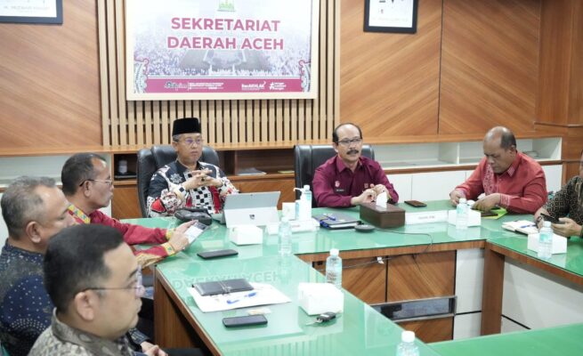 Kakanwil Kemenkumham Aceh Meurah Budiman, menyampaikan laporan capaian pengesahan badan hukum Koperasi Merah Putih Desa/Kelurahan dalam rapat evaluasi di Ruang Setda Aceh, Kamis (26/6/2025). (Foto: Ist)
