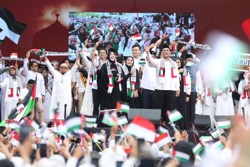 Penyanyi religi Opick bersama Wali Kota Banda Aceh Illiza Sa’aduddin Djamal memimpin konser amal penggalangan donasi Palestina yang berhasil mengumpulkan lebih dari Rp1 miliar di Stadion H Dimurthala, Minggu (27/7/2025). (Foto: Infoaceh.net)