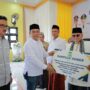 Bupati Aceh Besar Muharram Idris menyerahkan bantuan untuk masjid di Lhoong, usai membuka Jambore Kemanusiaan Peduli Kesehatan Masyarakat Daerah Pesisir di Gedung UDKP Kecamatan Lhoong, Aceh Besar, Sabtu (26/7). (Foto: Ist)