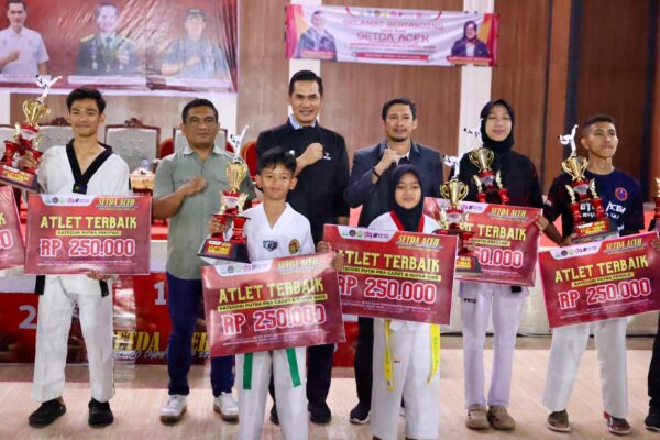 Plt Sekda Aceh, M Nasir menyerahkan piala untuk pemenang turnamen Setda Aceh Taekwondo Championship 2025, di Bale Meuseuraya Aceh, Banda Aceh, Ahad (3/8)